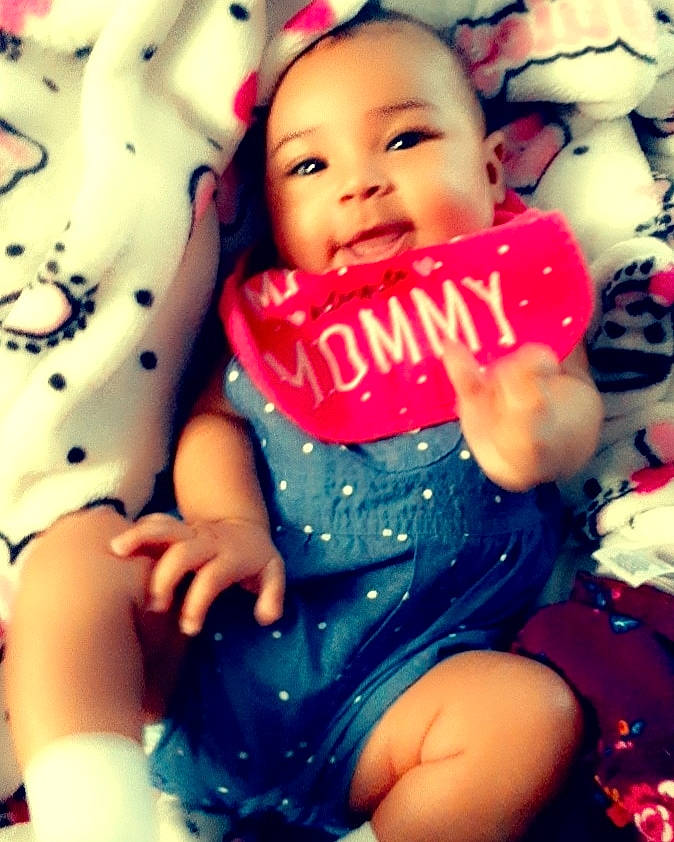 Ayanna is registered to the contest to win money with this photo: baby, baby_toddler_clothing, beauty, cheek, face, finger, happy, lip, mouth, nail, pattern, people, person, photograph, pink, skin, sleeve, smile, snapshot, thigh