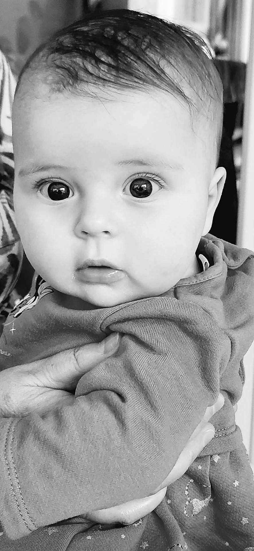 Sofia a rejoint le concours — aidez-le/la à gagner de superbes lots ! baby, infant, child, face, eyes, hand, clothing, portrait, black_and_white, cute, expression, person, young, holding, closeup, skin, eyelashes, nose, mouth, indoor