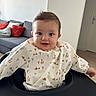 Isaac a rejoint le concours — aidez-le/la à gagner de superbes lots ! baby, child, face, smile, high_chair, bib, animal_print, giraffe, elephant, indoor, living_room, couch, pillow, curly_hair, cute, happy, infant, person, young_child, cozy