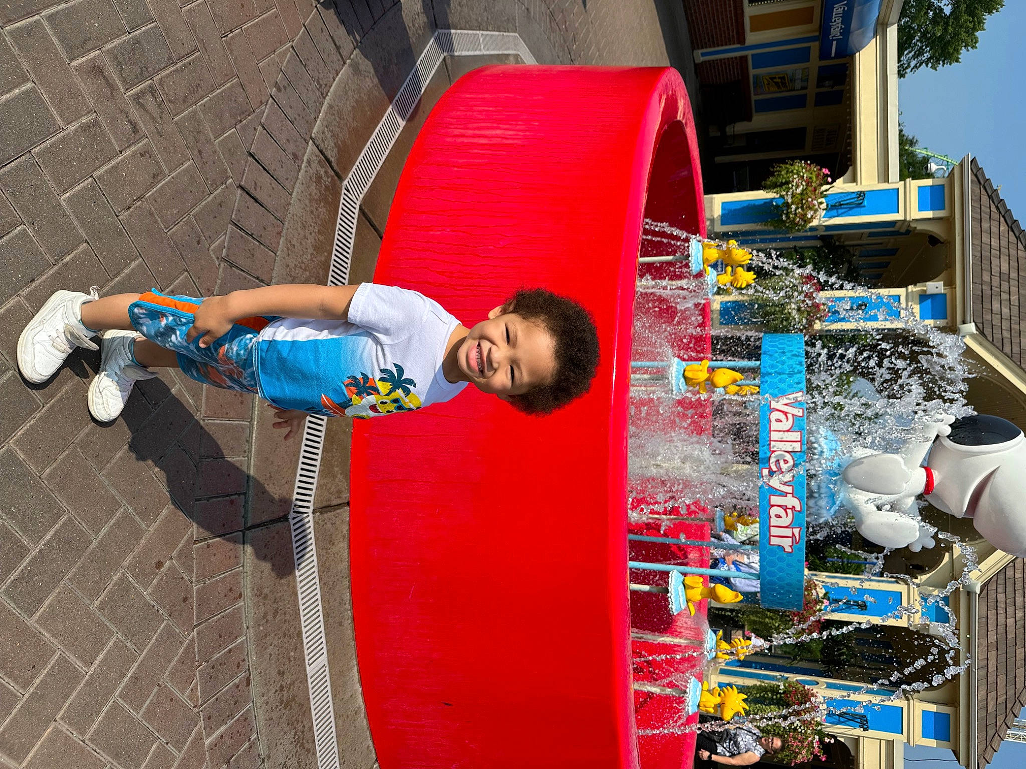 Apollo is registered to the contest to win money with this photo: child, city, electric_blue, engineering, fun, leisure, machine, pedestrian, person, plastic, play, recreation, sidewalk, street, t_shirt, toddler, travel, tree, water, world