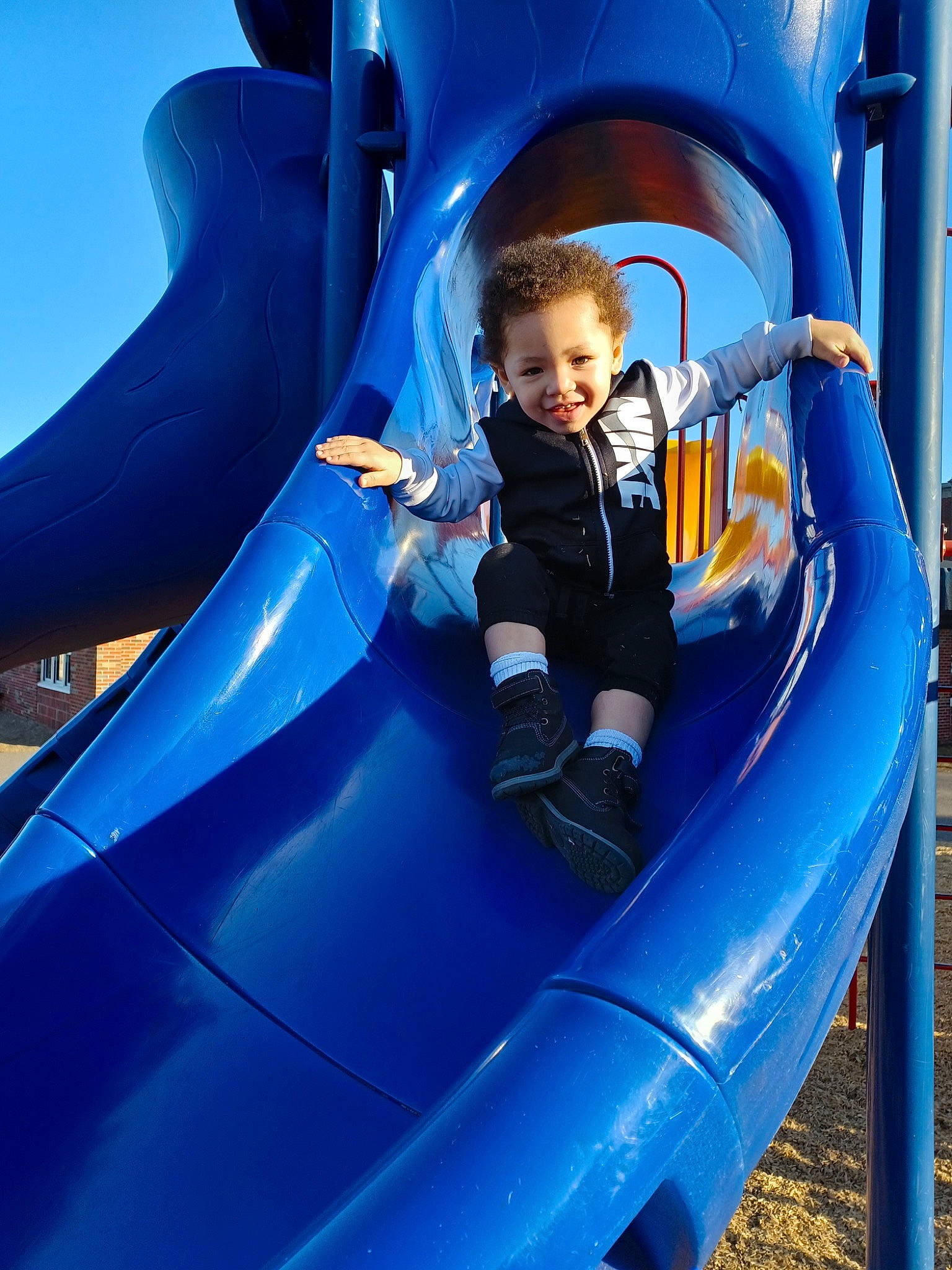 Apollo is registered to the contest to win money with this photo: baby_toddler_clothing, blue, child, chute, city, comfort, electric_blue, fun, inflatable, joy, leisure, organ, outdoor_play_equipment, person, photograph, play, playground, recreation, smile, snapshot