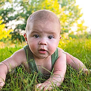 Sylas is registered to the contest to win money with this photo: baby, infant, grass, outdoor, sunlight, nature, green, tank_top, person, portrait, child, face, eyes, hands, summer, crawling, cute, young, curious, daylight