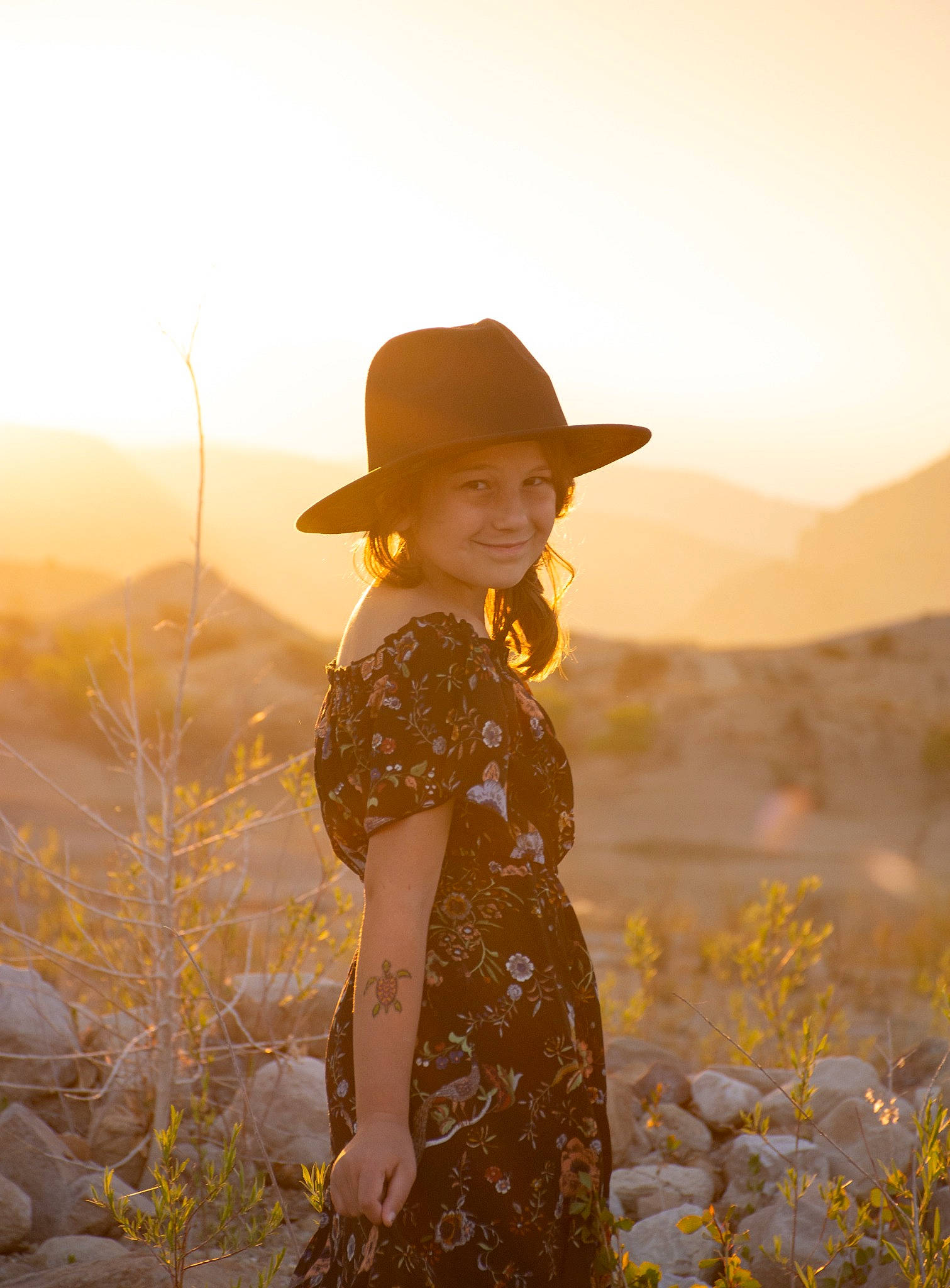 Rowan is registered to the contest to win money with this photo: clothing, dress, flash_photography, flower, grass, grassland, happy, hat, headgear, headwear, joy, landscape, meadow, people, people_in_nature, person, plant, rural_area, sky, standing