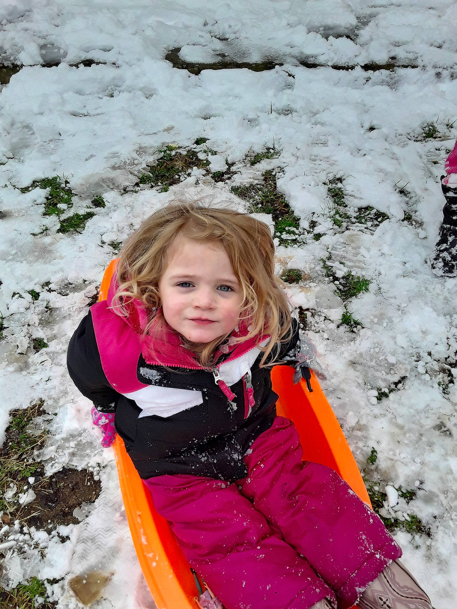 Kinsley is registered to the contest to win money with this photo: child, freezing, fun, geological_phenomenon, leisure, outerwear, person, play, playing_in_the_snow, recreation, smile, snow, vacation, winter