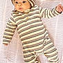 baby, infant, striped_clothing, knit_hat, blanket, lying_down, cute, child, portrait, one_person, indoors, soft_texture, warm_clothing, cozy, baby_girl, baby_boy, small_hands, sleepwear, newborn, looking_away