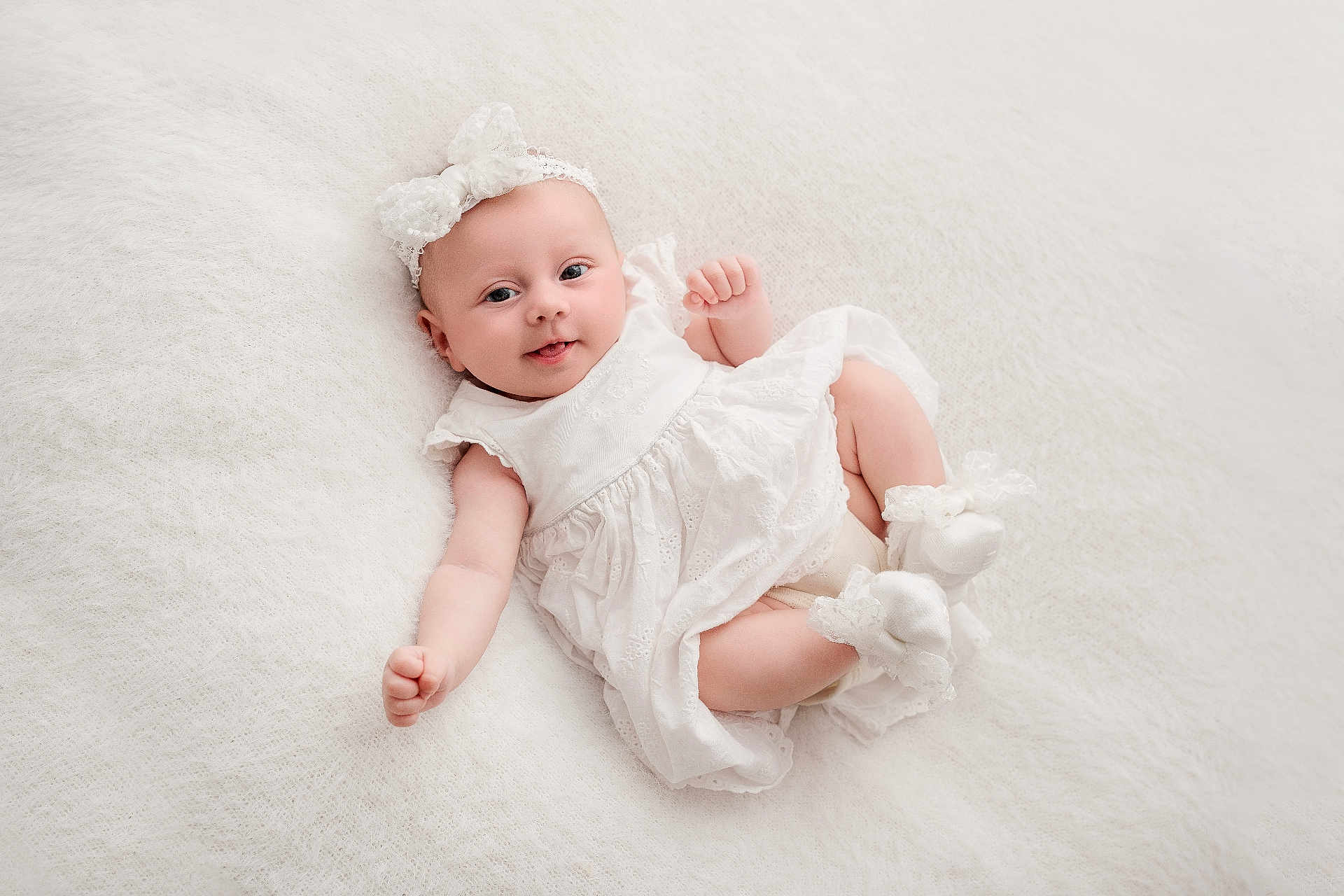 Nina participe au concours pour gagner de l'argent avec cette photo : baby, infant, white_dress, headband, smile, cute, soft_texture, lying_down, adorable, newborn, white_background, footwear, sock, happy, portrait, child, innocence, soft_lighting, peaceful, cozy