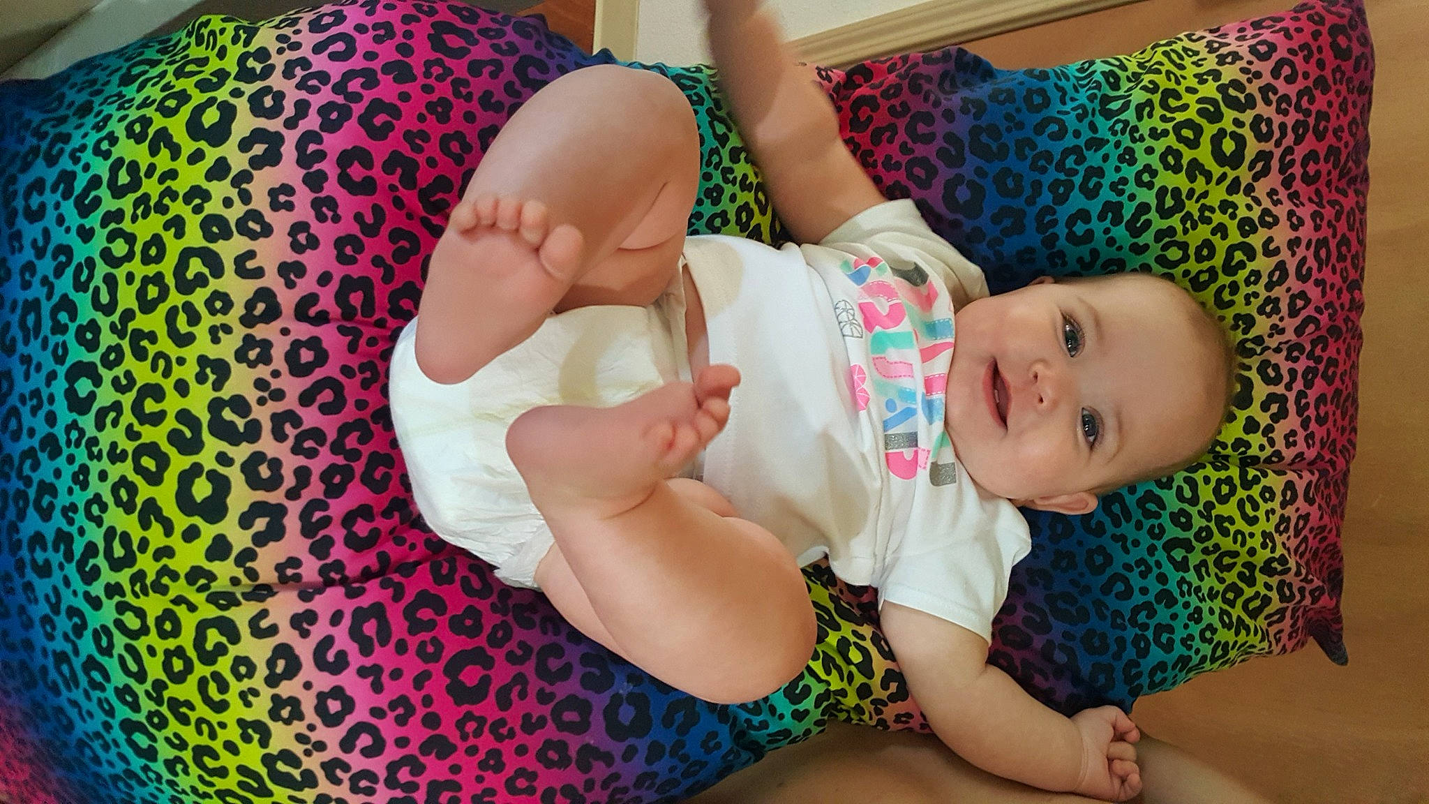 Melody is registered to the contest to win money with this photo: arm, baby, baby_products, baby_toddler_clothing, child, comfort, couch, finger, headgear, human_body, linens, nail, pattern, person, pink, room, sitting, skin, textile, thigh