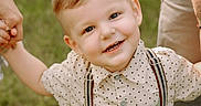 Ikaris is registered to the contest to win money with this photo: blonde_hair, blue_eyes, boy, casual_clothing, child, daylight, family, grass, happy, holding_hands, nature, outdoor, people, polka_dot_shirt, portrait, smiling, summer, suspenders, tattoo, toddler
