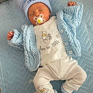 Draco is registered to the contest to win money with this photo: baby, newborn, sleeping, pacifier, blue_hat, knitwear, blue_blanket, baby_clothes, infant, cute, cozy, soft_texture, white_pants, baby_booties, lying_down, peaceful, child, portrait, indoor, sleep