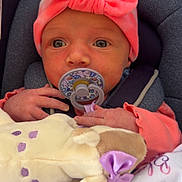 Amelia is registered to the contest to win money with this photo: baby, infant, pacifier, headband, pink, plush_toy, blanket, car_seat, child, cute, soft_toy, newborn, clothing, comfort, portrait, indoors, face, hand, expression, rest