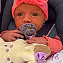 baby, infant, pacifier, headband, pink, plush_toy, blanket, car_seat, child, cute, soft_toy, newborn, clothing, comfort, portrait, indoors, face, hand, expression, rest
