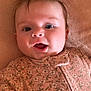 Juniper is registered to the contest to win money with this photo: baby, infant, face, expression, onesie, floral_pattern, lying_down, blanket, cute, child, skin, hair, mouth_open, eyes, adorable, soft_texture, portrait, indoors, young, person