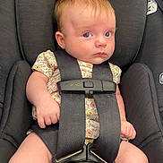 Juniper is registered to the contest to win money with this photo: baby, infant, car_seat, seatbelt, pink_bow, floral_outfit, blue_eyes, child, sitting, safety, straps, cute, young_child, indoor, portrait, close_up, serious_expression, skin, hair, hands