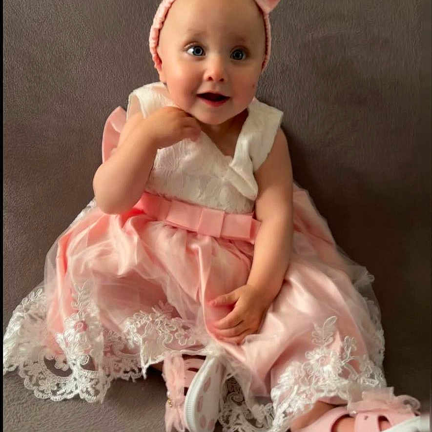 Louna participe au concours pour gagner de l'argent avec cette photo : baby, bonnet, cap, clothing, costume, couch, doll, dress, face, fashion, formalwear, gown, hat, head, newborn, person, photography, portrait, sitting, toy