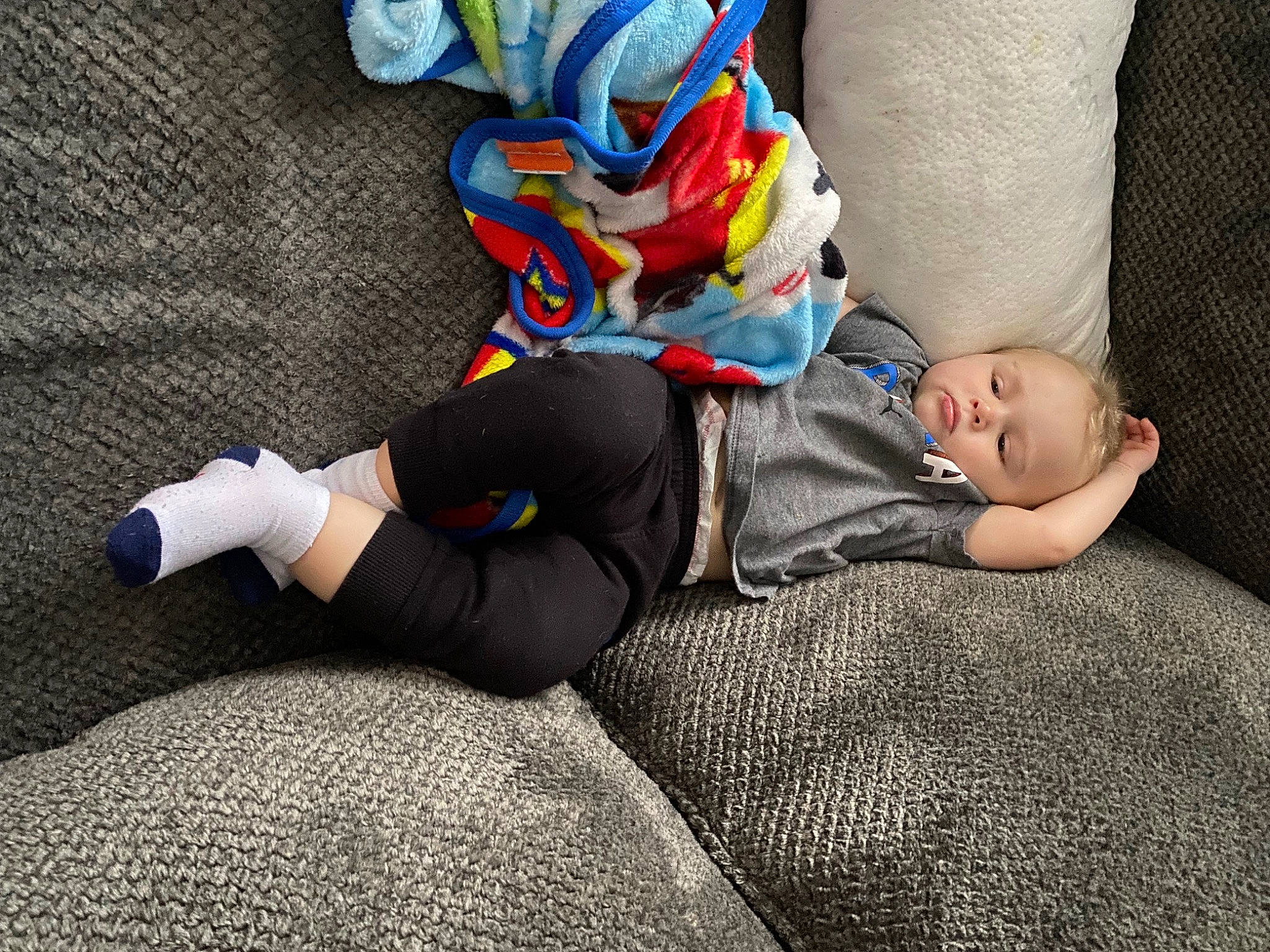 Keegan is registered to the contest to win money with this photo: baby, boot, carmine, child, comfort, flooring, foot, grass, human_leg, knee, lap, linens, nap, person, personal_protective_equipment, sitting, sleep, sock, sportswear, thigh