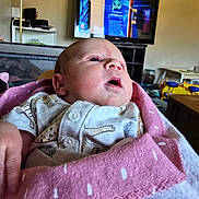 Fraya joined the competition — help win amazing prizes! baby, infant, blanket, pink_blanket, clothing, indoor, television, face, head, person, newborn, gazing, curious, sitting, home, furniture, living_room, soft_texture, casual, portrait