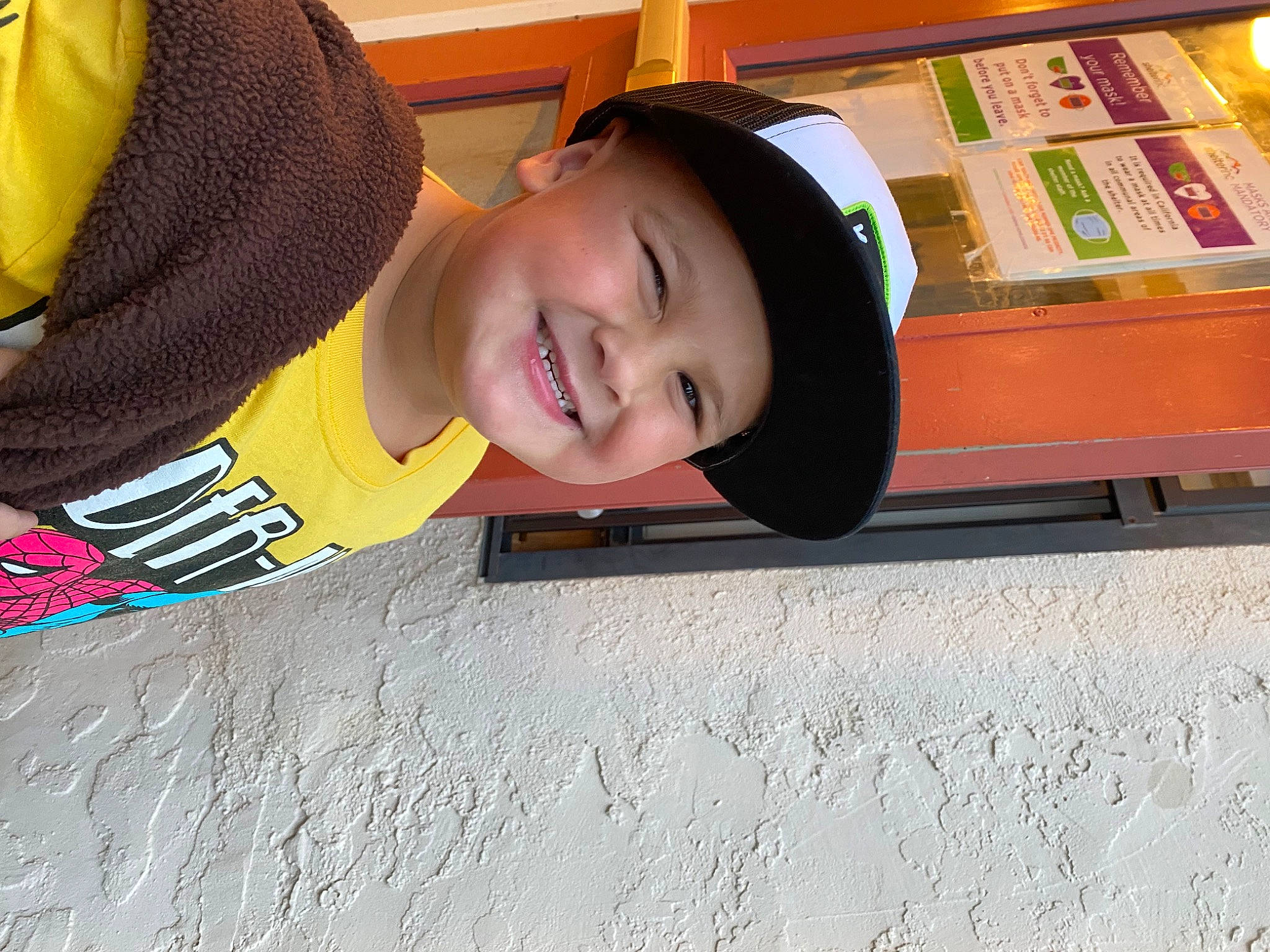 Kaidyn joined the competition — help win amazing prizes! asphalt, cap, child, face, fashion_accessory, flooring, fun, happy, headgear, headwear, joy, leisure, person, personal_protective_equipment, play, recreation, sitting, sleeve, smile, t_shirt