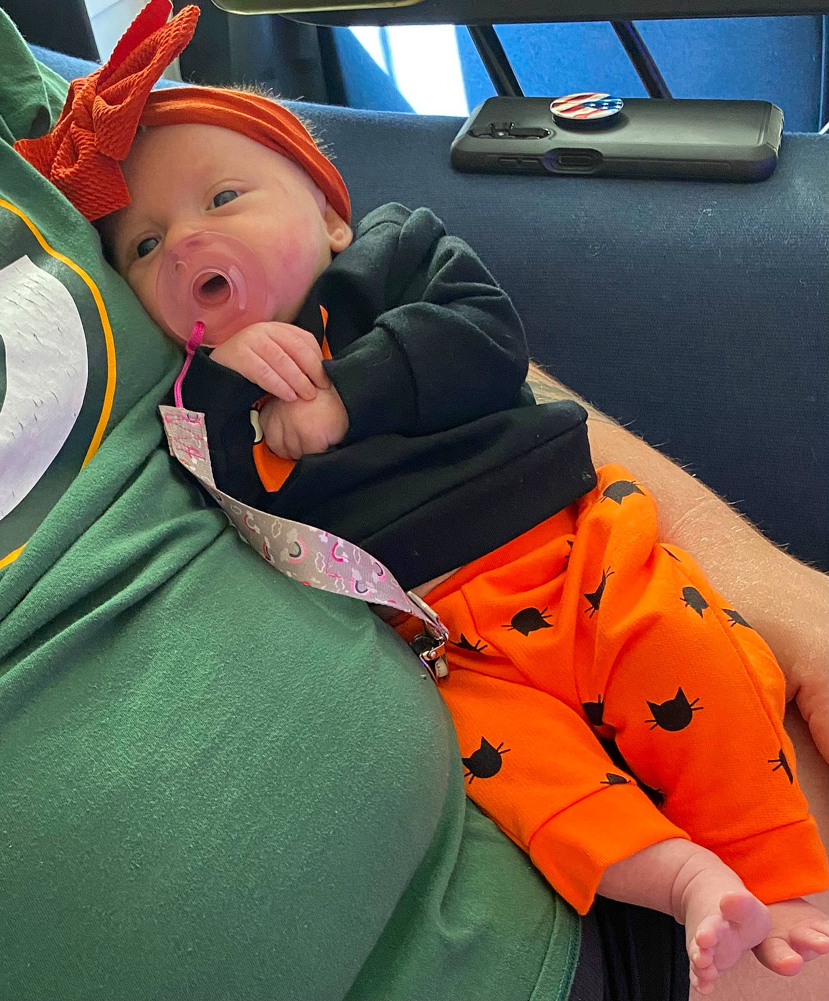 Mckenna is registered to the contest to win money with this photo: auto_part, baby, baby_products, baby_safety, baby_toddler_clothing, bag, car_seat, child, comfort, costume_hat, family_car, hat, headwear, orange, person, personal_protective_equipment, polar_fleece, sitting, sun_hat, toddler