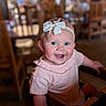 Winslette joined the competition — help win amazing prizes! baby, baby_girl, blue_eyes, bow, cheerful, child, closeup, cute, happy, headband, high_chair, indoor, infant, person, pink_clothing, portrait, restaurant, seated, smile, wooden_furniture