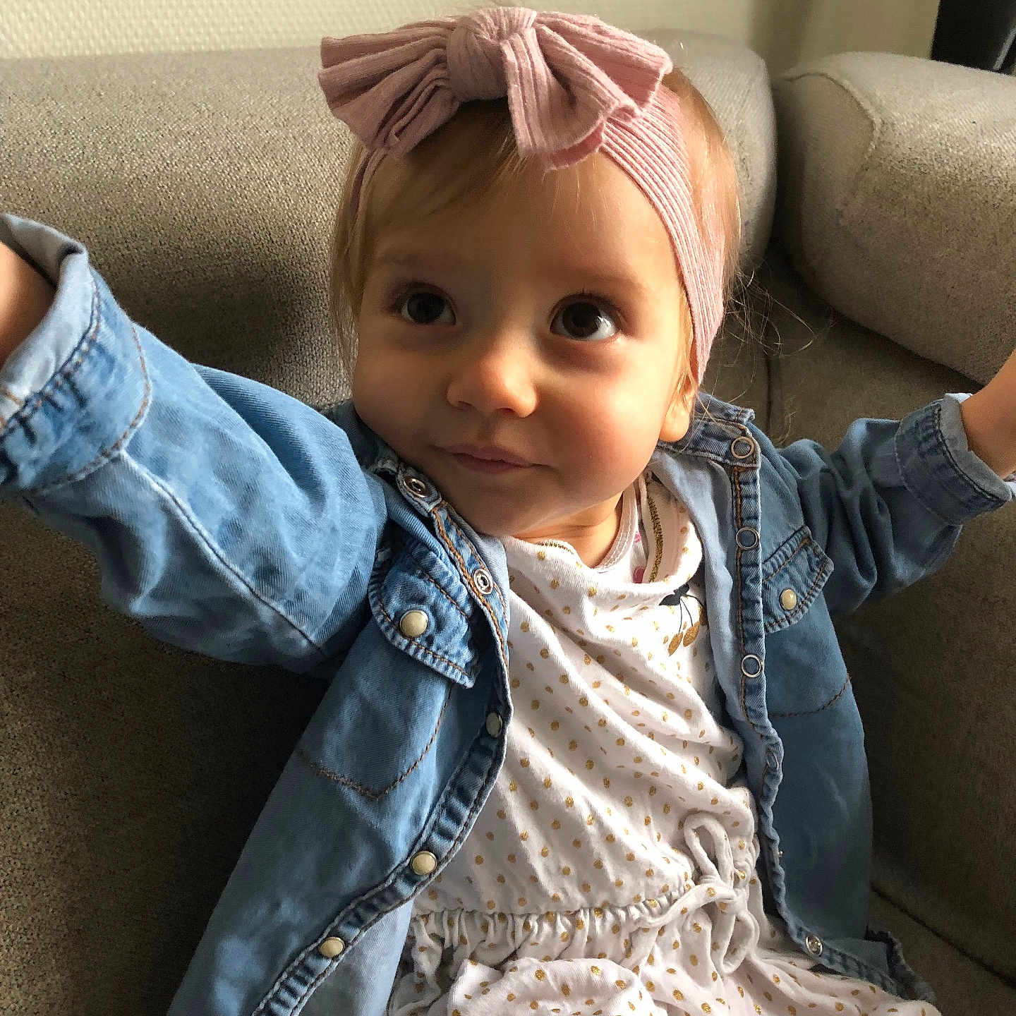 Eloa participe au concours pour gagner de l'argent avec cette photo : bow, casual_clothing, child, couch, cozy, curious, cute, denim_jacket, dress, girl, headband, indoor, person, polka_dots, portrait, seated, smiling, soft_lighting, toddler, young_child