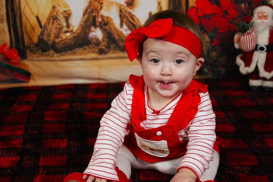 Amaia is registered to the contest to win money with this photo: baby, baby_toddler_clothing, carmine, cheek, christmas, costume, costume_accessory, fictional_character, headwear, holiday, linens, pattern, person, picture_frame, plaid, red, santa_claus, stuffed_toy, tartan, textile