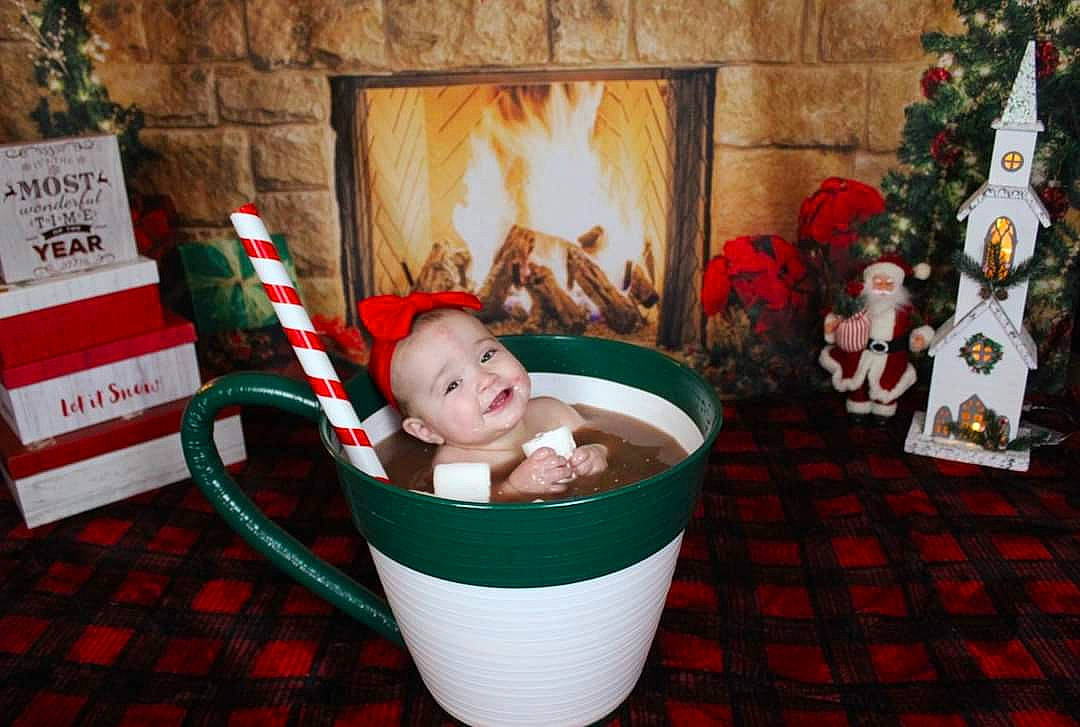 Amaia is registered to the contest to win money with this photo: baby, basket, christmas, christmas_decoration, christmas_eve, christmas_ornament, fictional_character, fireplace, hearth, holiday, home_accessories, interior_design, joy, ornament, person, plaid, toy