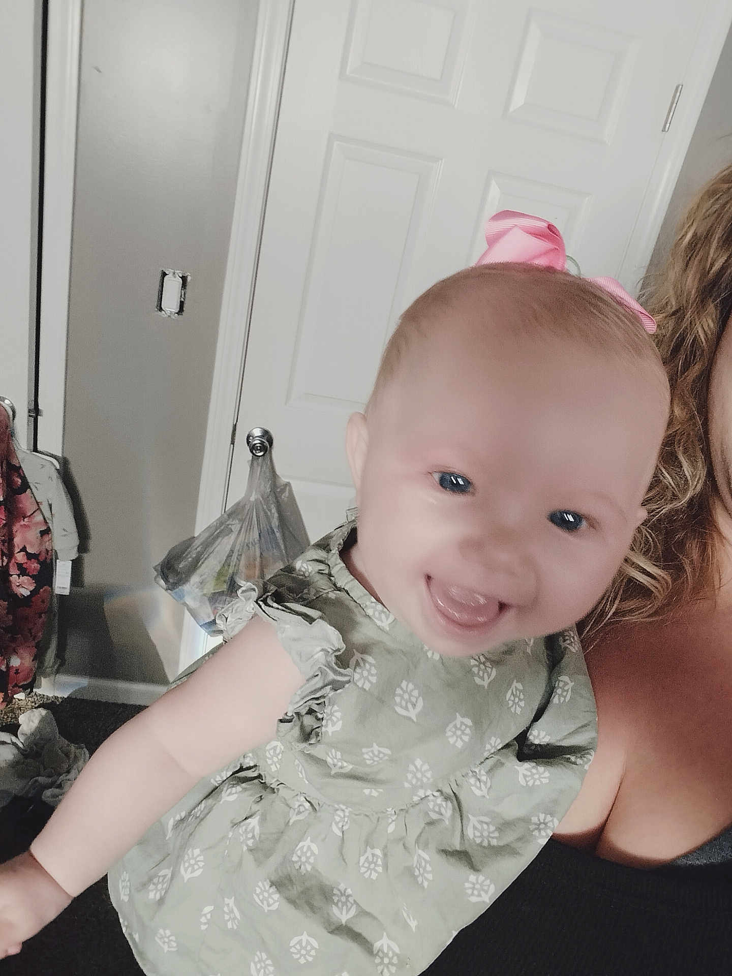 Ivy joined the competition — help win amazing prizes! baby, child, smiling, pink_bow, dress, person, portrait, indoor, door, face, happy, holding, arm, human, clothing, skin, head, young, cute, infant