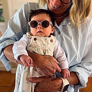 Thaïs participe au concours pour gagner de l'argent avec cette photo : baby, child, adult, woman, glasses, sunglasses, holding, smile, indoor, clothing, overalls, watch, person, portrait, skin, hand, face, hair, floor, background