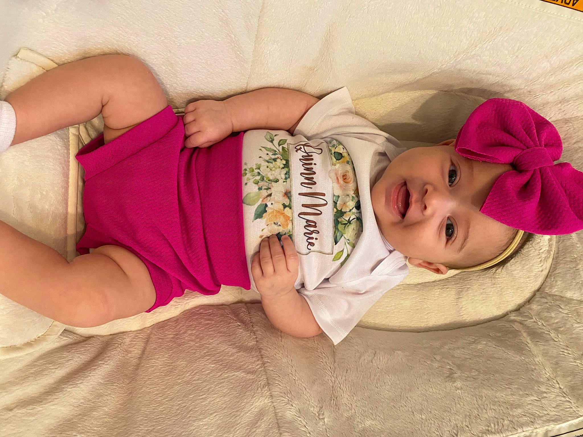 Quinn is registered to the contest to win money with this photo: baby, baby_toddler_clothing, child, comfort, elbow, eye, eyelash, finger, hand, happy, hat, headgear, headwear, human_body, linens, lip, person, pink, skin, textile