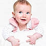 baby, infant, smiling, cute, polka_dot, white_background, pink_vest, blanket, hands, face, portrait, child, happy, closeup, soft_texture, studio, clothing, light_skin, short_hair, bright_eyes