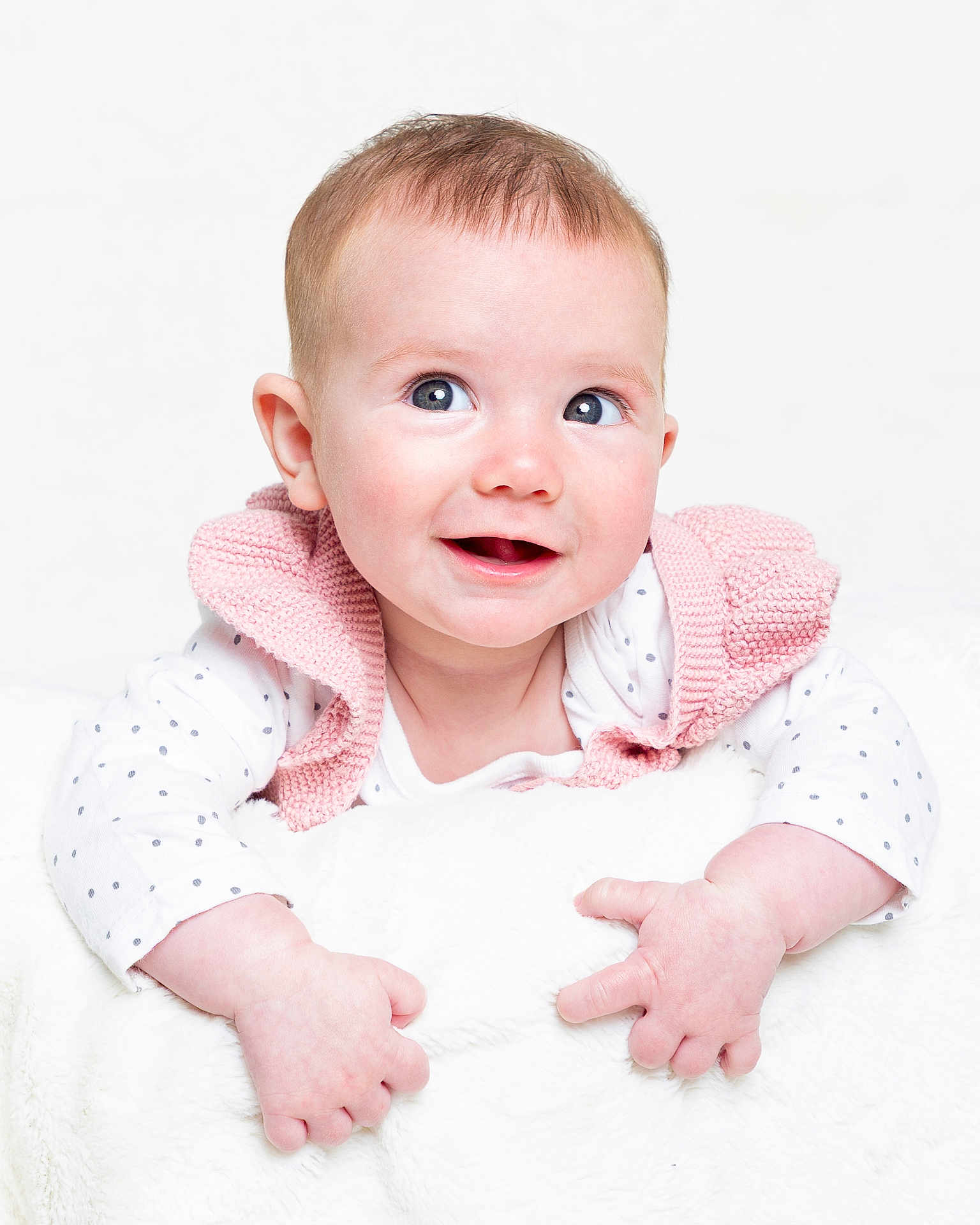 Penelope joined the competition — help win amazing prizes! baby, infant, smiling, cute, polka_dot, white_background, pink_vest, blanket, hands, face, portrait, child, happy, closeup, soft_texture, studio, clothing, light_skin, short_hair, bright_eyes