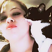 Kiki joined the competition — help win amazing prizes! person, cat, black_and_white_cat, face, close_up, licking, affection, indoor, makeup, shoulder, whiskers, fur, pet, animal, skin, human, head, eyelids, nose, lips