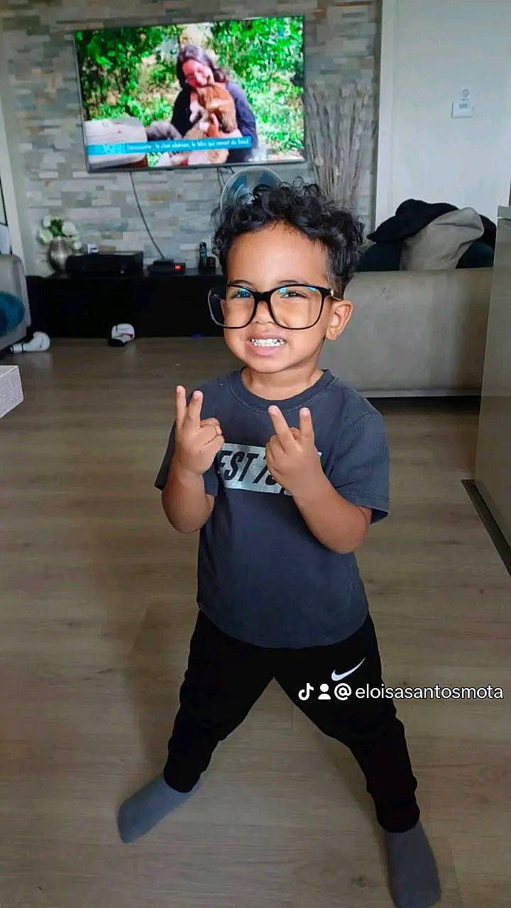 Kassim participe au concours pour gagner de l'argent avec cette photo : baby_toddler_clothing, event, eyewear, flash_photography, floor, flooring, fun, gesture, glasses, happy, joint, joy, leisure, person, sleeve, t_shirt, television, thumb, toddler, vision_care