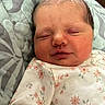 Emma is registered to the contest to win money with this photo: newborn, baby, infant, sleeping, face, portrait, floral_clothing, blanket, pillow, bedding, indoors, close_up, peaceful, resting, closed_eyes, hair, cheeks, child, soft_lighting, photography