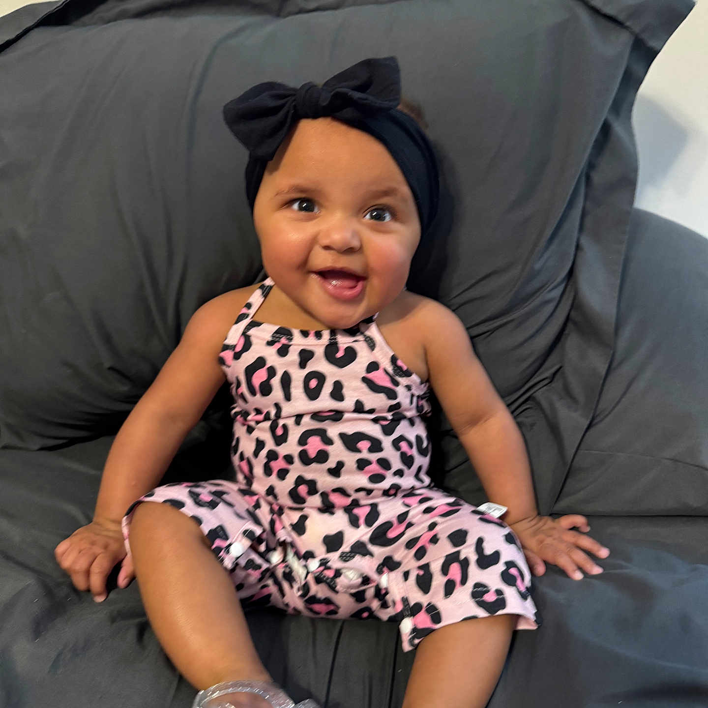Aminah joined the competition — help win amazing prizes! baby, babylaughing, clothing, couch, cushion, dress, face, footwear, furniture, happy, hat, head, homedecor, pajamas, person, photography, portrait, shoe, sitting, smile