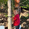 child, boy, horse, animal, outdoors, woodland, forest, tree, nature, smiling, portrait, red_shirt, black_pants, halter, bucket, rope, sunlight, rocks, equestrian, rural