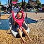 Bentley is registered to the contest to win money with this photo: barefoot, blue_sky, boy, casual_clothing, child, fun, leisure, outdoor, park, people, play_equipment, playground, recreation, safety_bar, smiling, summer, sunlight, swing, trees, woodchips
