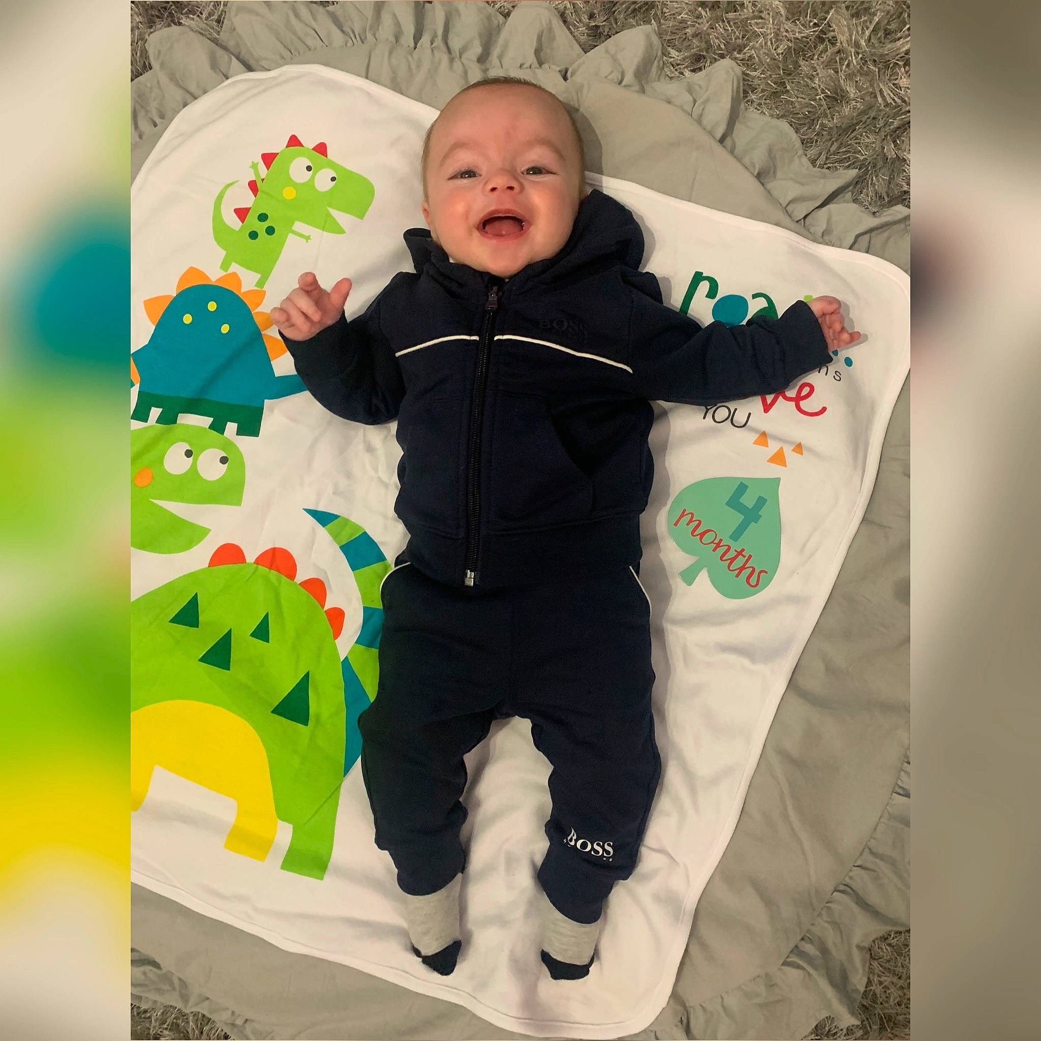 Chester is registered to the contest to win money with this photo: arm, baby, baby_products, baby_safety, baby_toddler_clothing, child, comfort, cool, face, facial_expression, font, gesture, happy, linens, outerwear, pattern, person, sleeve, t_shirt, textile