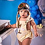 Liam is registered to the contest to win money with this photo: aviator_hat, baby, birthday, blue_balloons, celebration, child, cute, expression, face, hat, indoor, music, one_year_old, party, photography, piano, romper, standing, toddler, toy