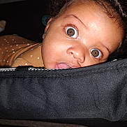 Cullen joined the competition — help win amazing prizes! baby, child, face, eyes, curious, brown_clothing, fabric, black, closeup, portrait, indoor, infant, expression, wide_eyes, cute, person, skin, head, hair, tongue