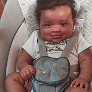 Cullen joined the competition — help win amazing prizes! baby, child, curly_hair, smile, baby_seat, straps, elephant_toy, clothing, sitting, indoor, infant, cute, happy, person, skin, hand, footwear, sock, patterned, fabric