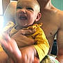 Avery is registered to the contest to win money with this photo: baby, child, person, adult, yellow_clothing, indoor, playful, cute, happy, hand, blur, shirtless, window, wood, teal_wall, holding, portrait, smile, face, family