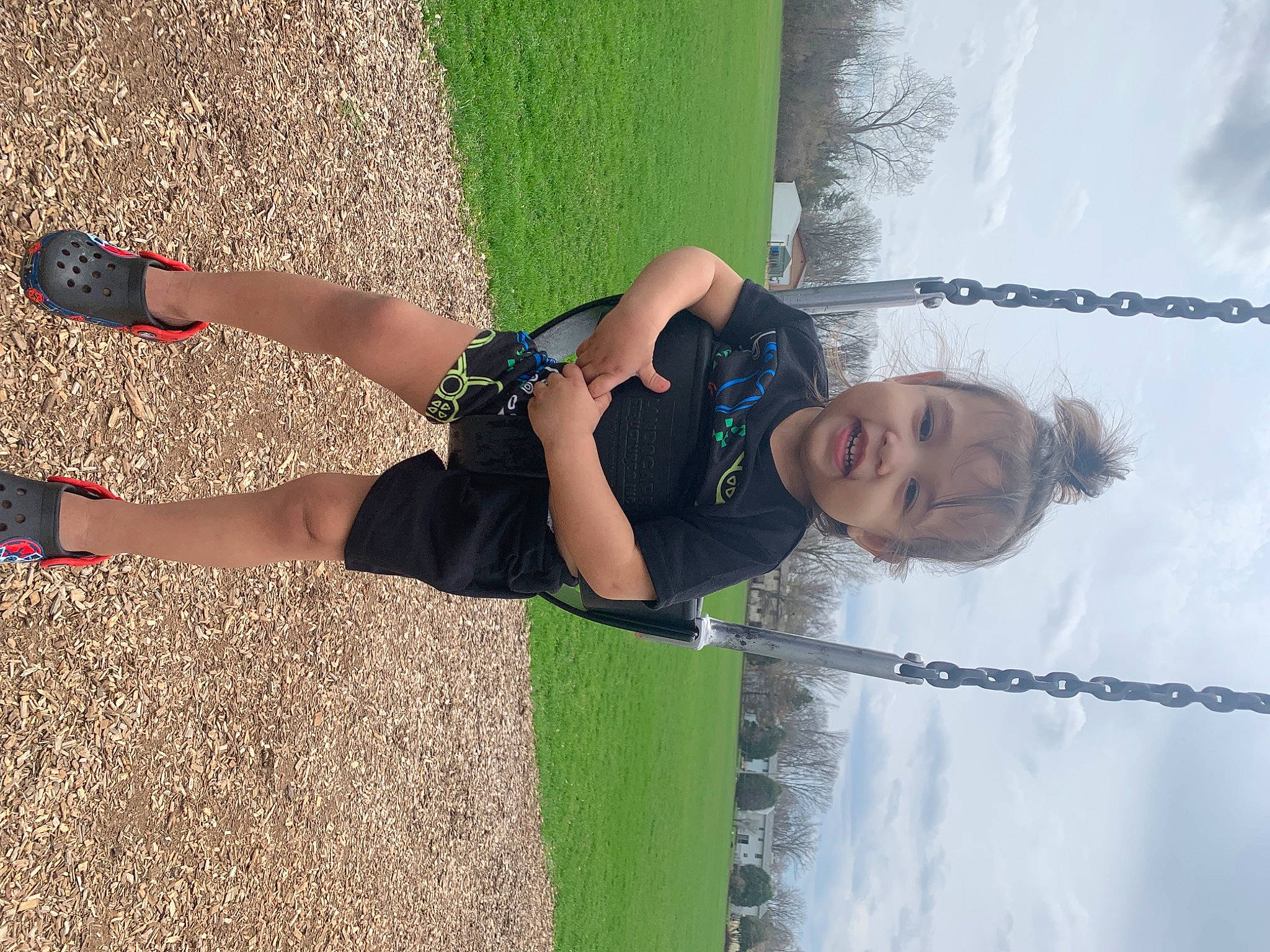 Marcellus is registered to the contest to win money with this photo: asphalt, elbow, fun, grass, happy, human_leg, knee, leisure, people_in_nature, person, plant, recreation, shadow, shorts, sky, smile, sock, thigh, tree, water