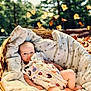 baby, basket, blanket, autumn, falling_leaves, outdoor, nature, infant, cute, cozy, wicker, star_pattern, child, portrait, soft_lighting, seasonal, relaxing, clothing, skin, peaceful