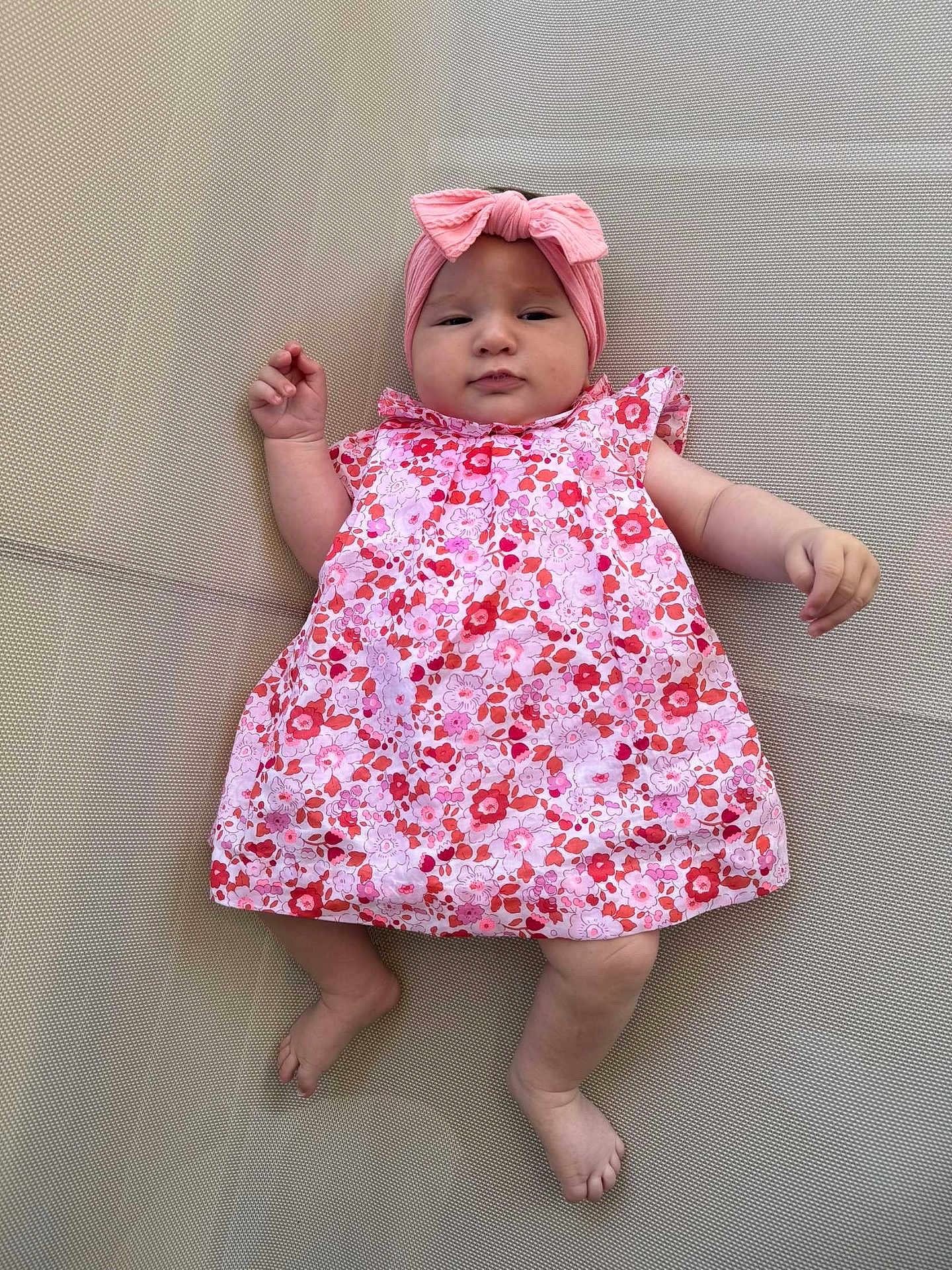 Séphora a rejoint le concours — aidez-le/la à gagner de superbes lots ! baby, infant, child, pink_dress, headband, floral_pattern, barefoot, lying_down, textured_surface, cute, portrait, skin, hand, foot, face, young_child, clothing, fashion, indoors, expression