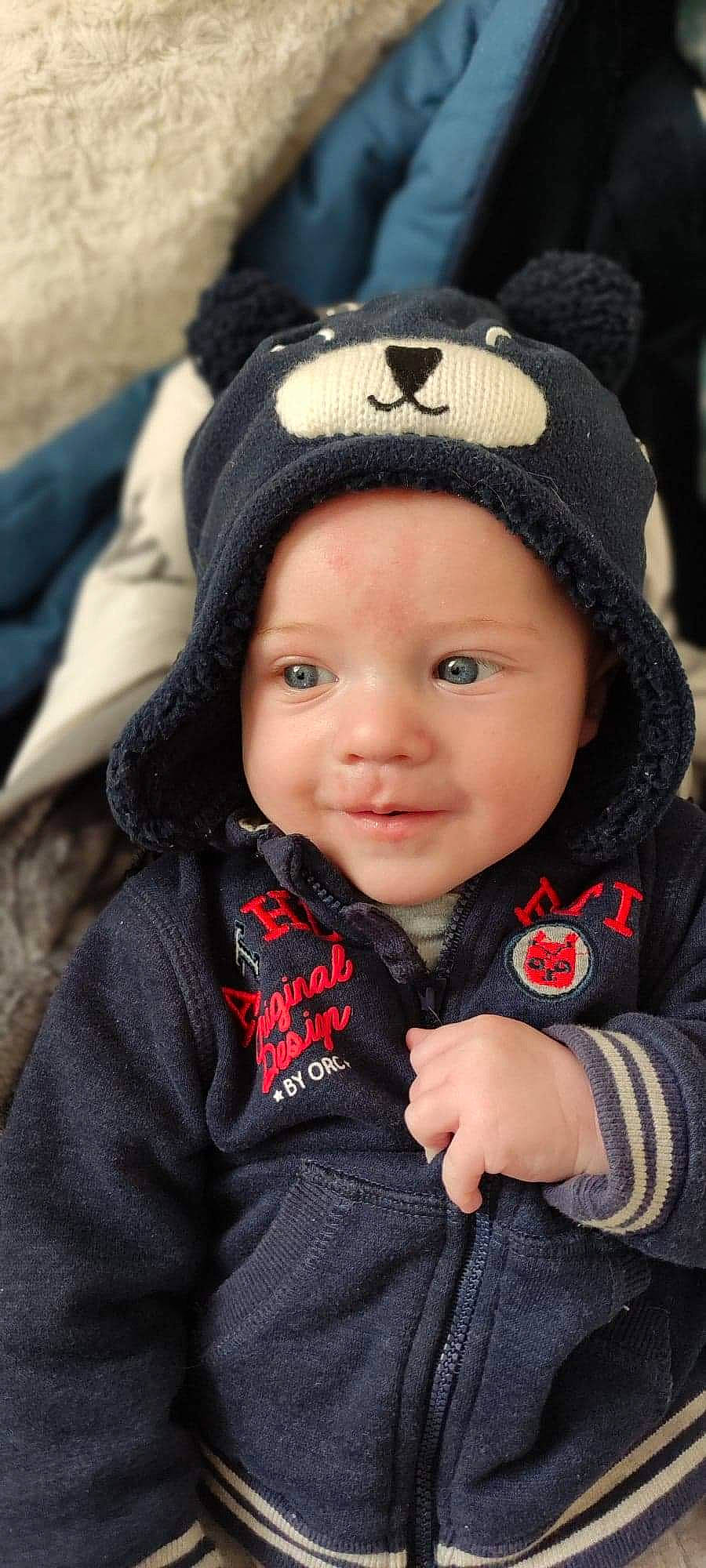 Eliott participe au concours pour gagner de l'argent avec cette photo : blue, cap, cheek, clothing, daytime, eye, face, finger, fun, grass, green, hair, head, headwear, human, jacket, lip, people, person, product