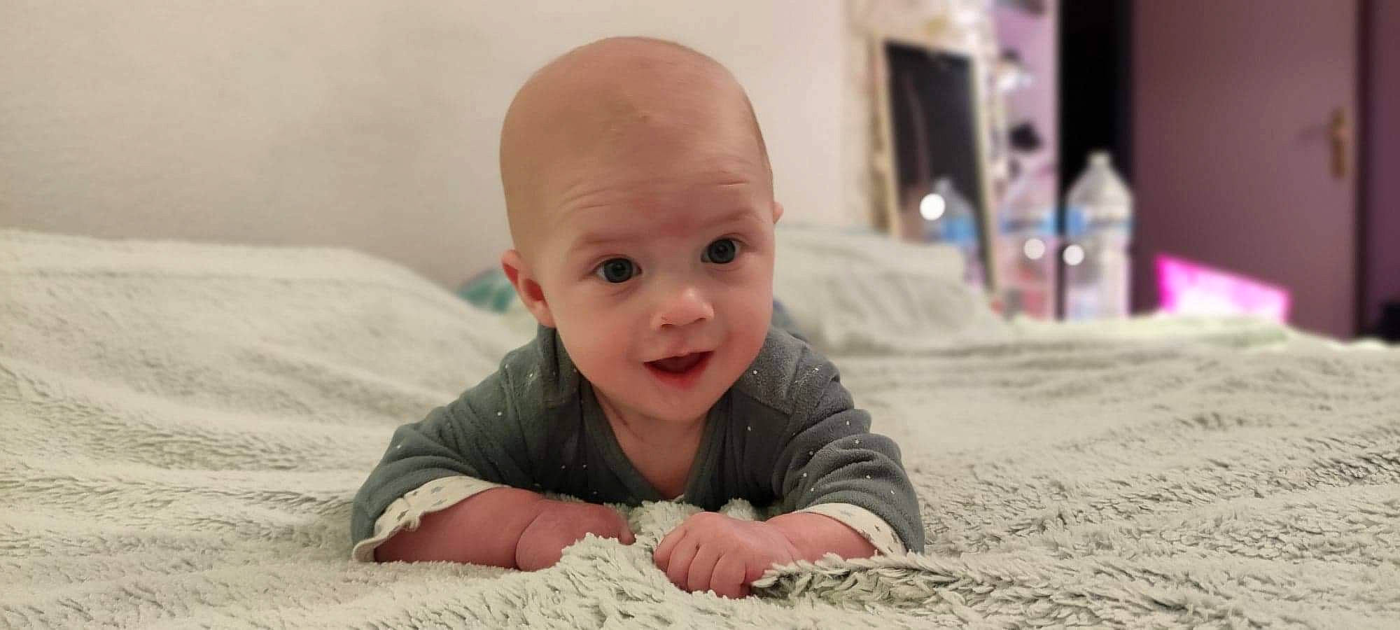 Eliott a rejoint le concours — aidez-le/la à gagner de superbes lots ! baby, baby_crawling, baby_toddler_clothing, bed, cheek, comfort, crawling, linens, person, pink, sand, skin, toddler, tummy_time