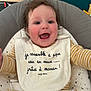 Jade participe au concours pour gagner de l'argent avec cette photo : baby, child, smiling, happy, indoor, curly_hair, bib, striped_clothing, seat, cushion, face, person, infant, closeup, cheeks, cute, playful, comfortable, expression, joy
