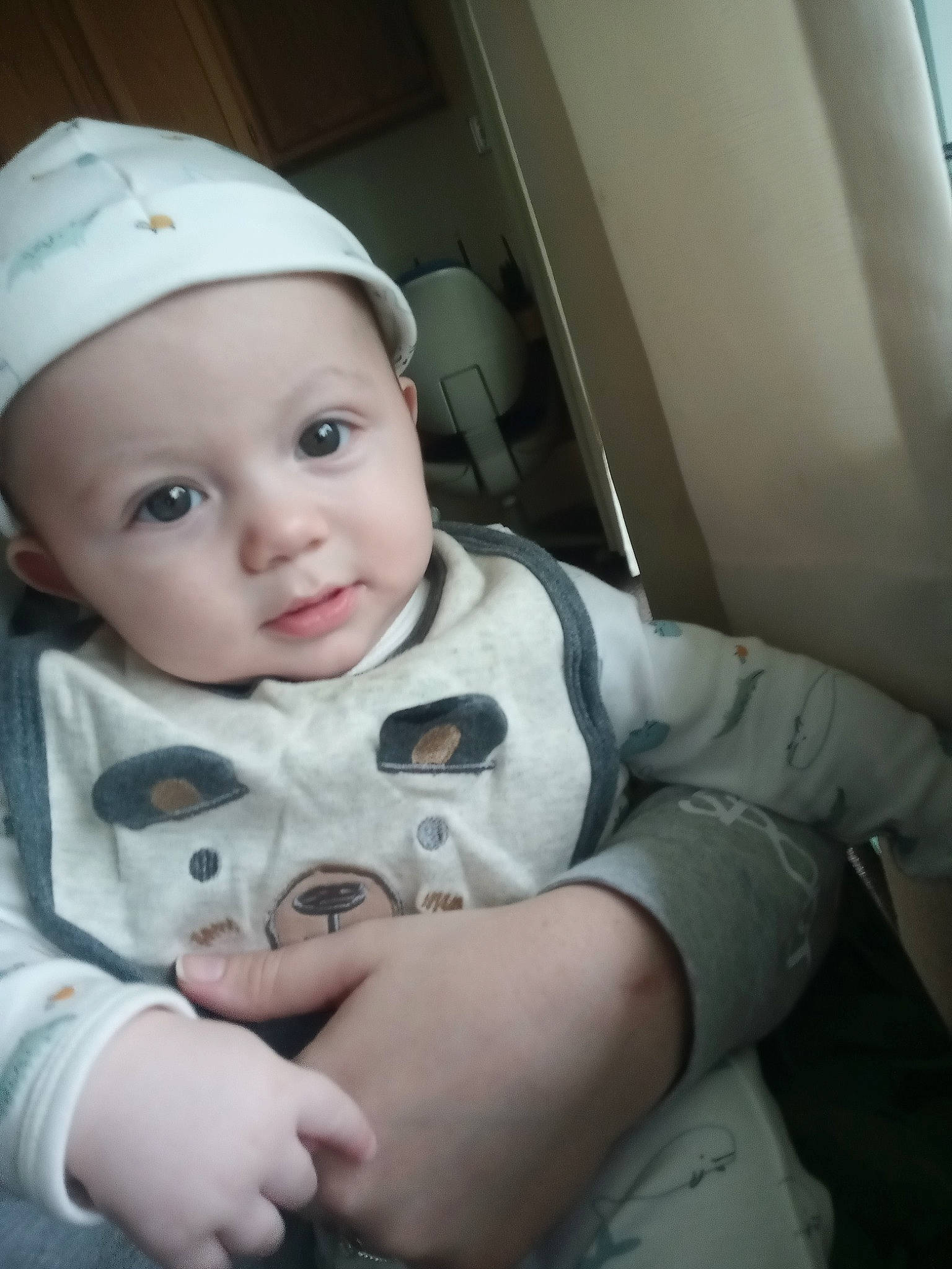 Evren is registered to the contest to win money with this photo: arm, baby, baby_toddler_clothing, cap, cheek, child, chin, clothing, comfort, flash_photography, fun, gesture, happy, hat, headwear, nose, person, sitting, skin, sleeve