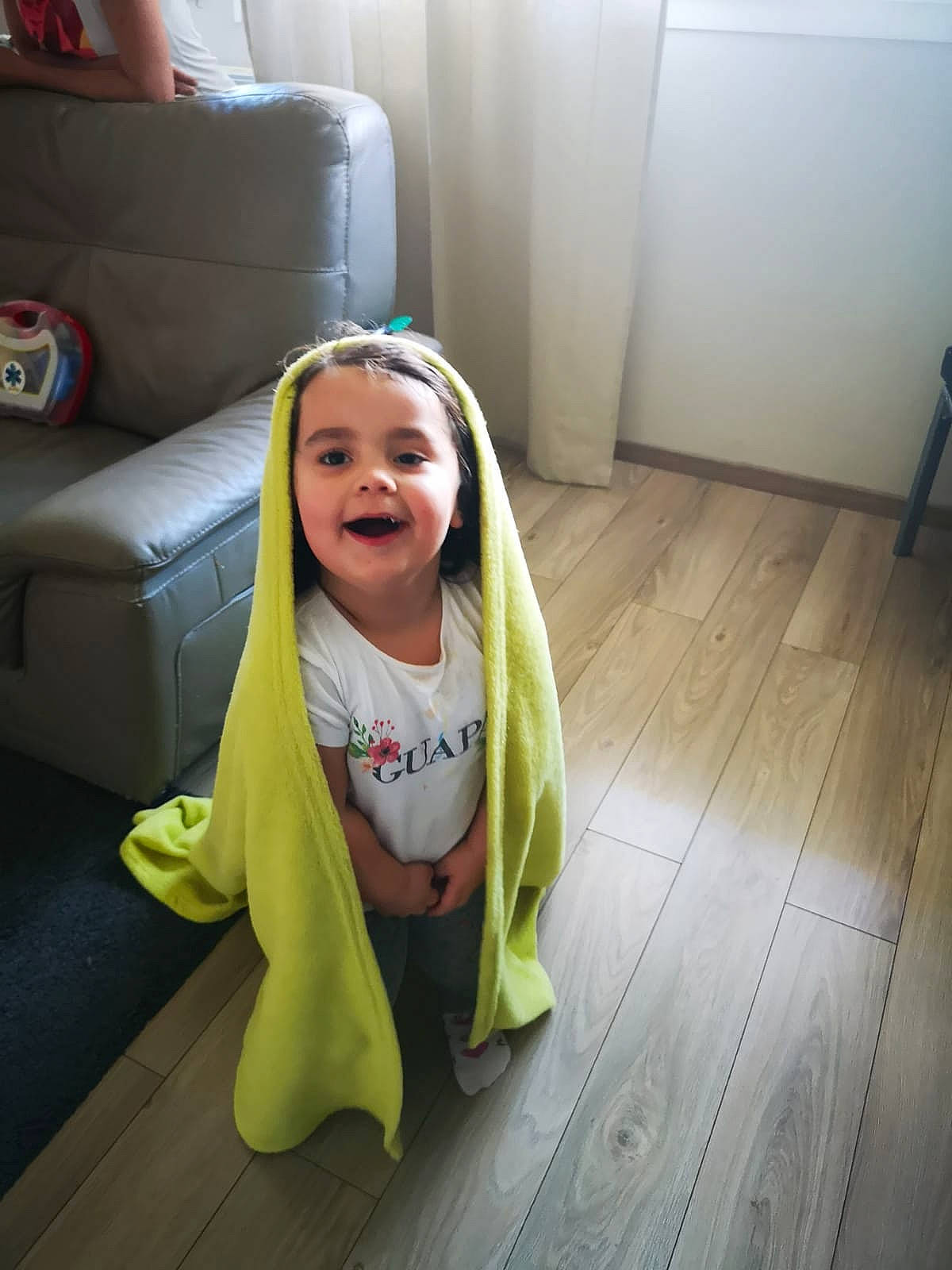 Milla a rejoint le concours — aidez-le/la à gagner de superbes lots ! baby, child, floor, flooring, fun, green, hardwood, head, joy, outerwear, person, play, sitting, skin, smile, toddler, wood, yellow